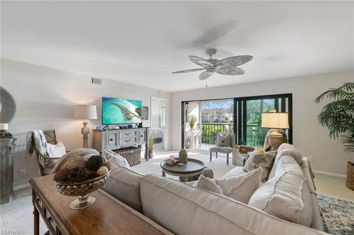 Carpeted living room featuring ceiling fan