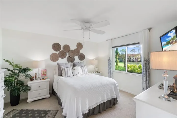 Bedroom with light colored carpet and ceiling fan