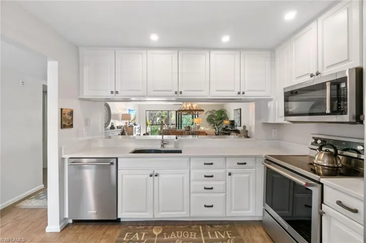 Kitchen featuring white cabinets, hardwood / wood-style floors, stainless steel appliances, and sink