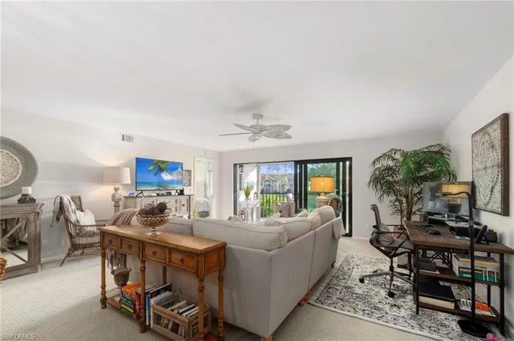 Carpeted living room featuring ceiling fan