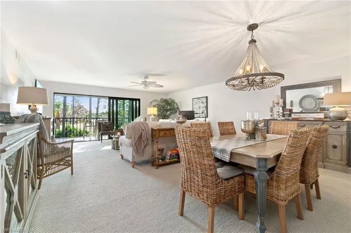 Dining space with light colored carpet and ceiling fan