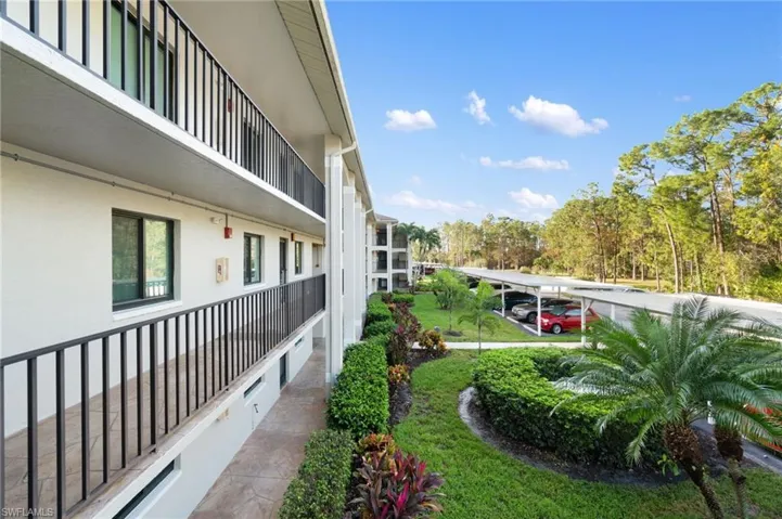 View of yard with a balcony and a carport