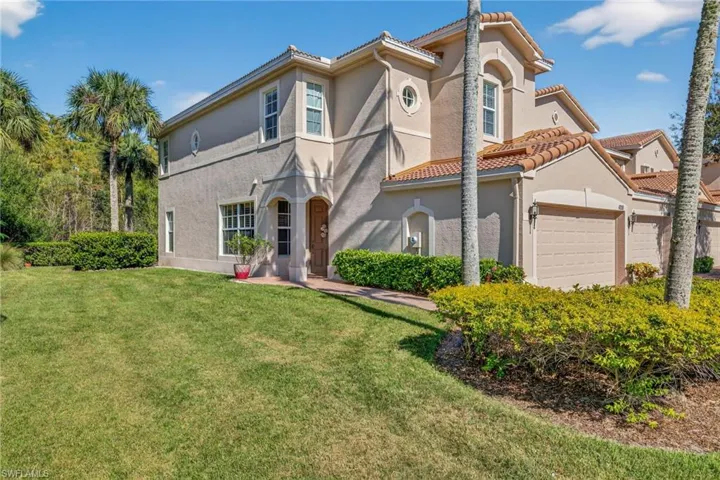 Mediterranean / spanish house with stucco siding, a front lawn, and a tile roof
