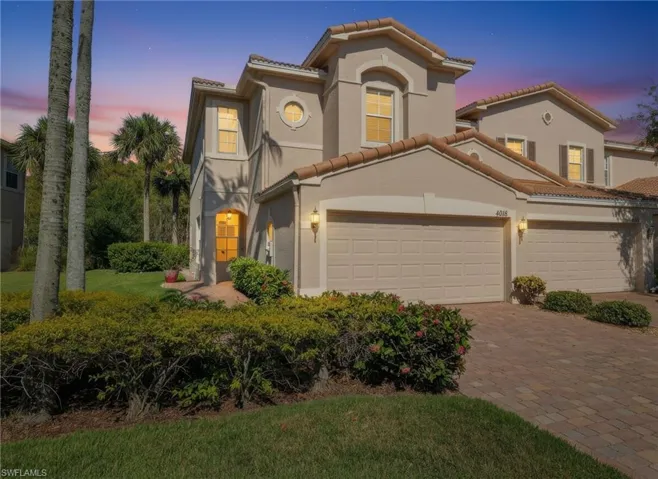 Mediterranean / spanish-style house with a tiled roof, a garage, decorative driveway, stucco siding, and a front yard