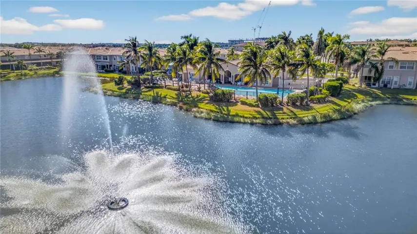 Aerial view of residential area featuring a pool area and a nearby body of water