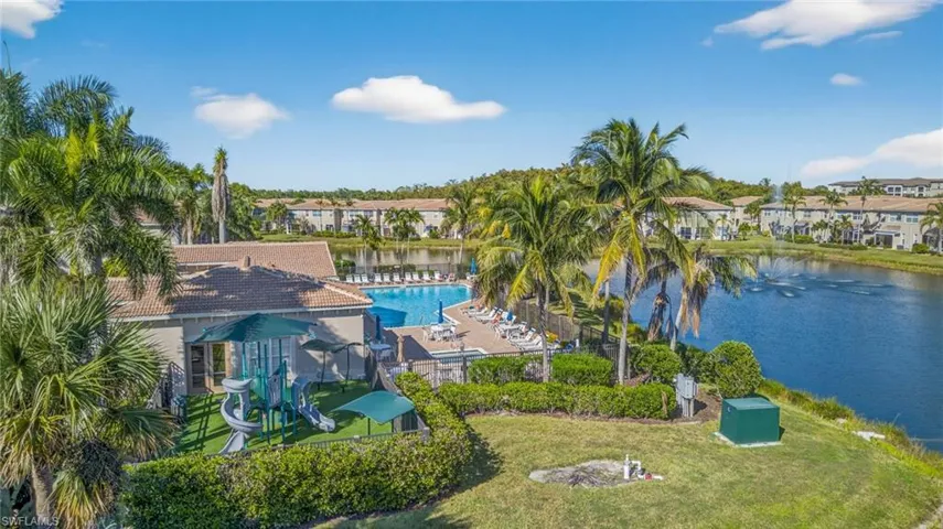 Drone / aerial view of a nearby body of water and a pool