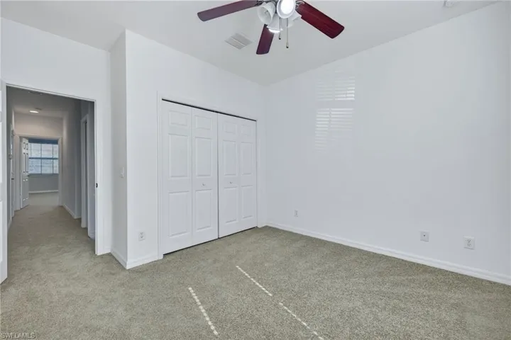 Unfurnished bedroom with carpet flooring, a closet, and a ceiling fan