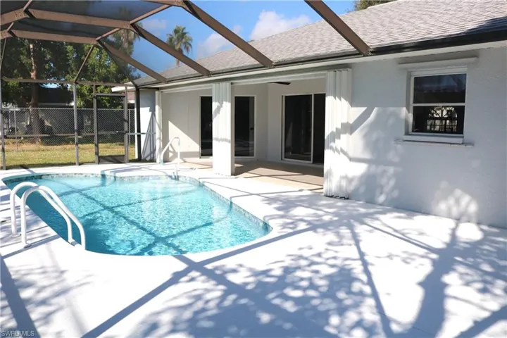 View of pool with a patio, a sunroom, and glass enclosure
