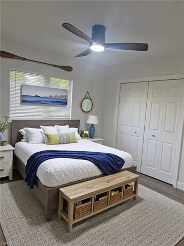 Bedroom featuring dark wood finished floors, a closet, and a ceiling fan