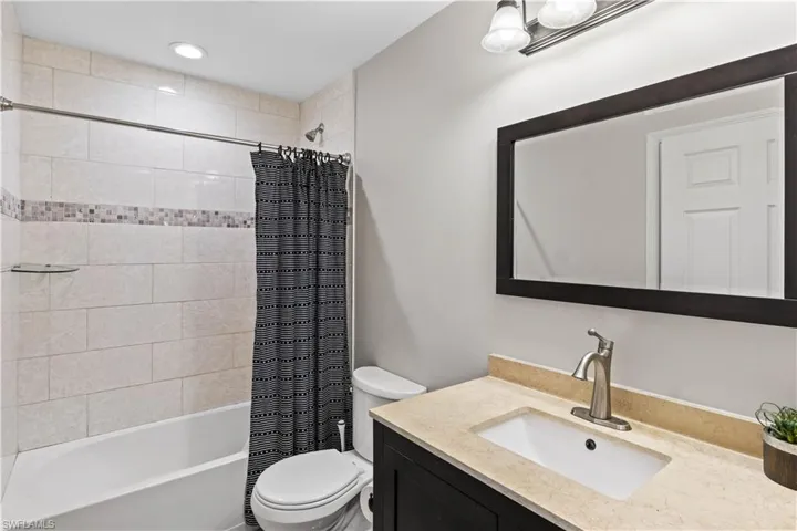Full bathroom featuring toilet, vanity, and shower / tub combo with curtain