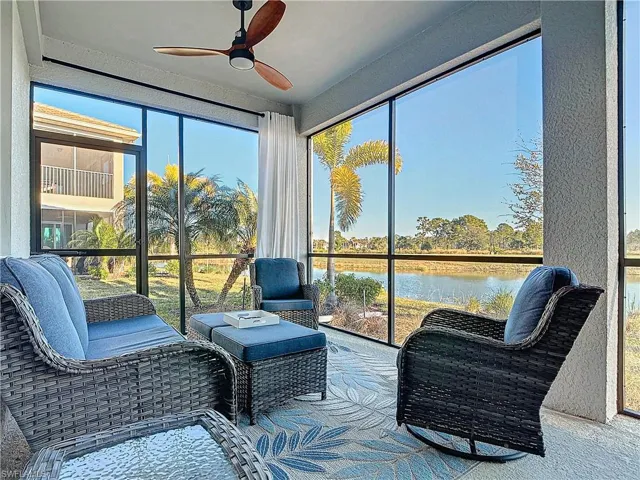 Sunroom with ceiling fan and a water view