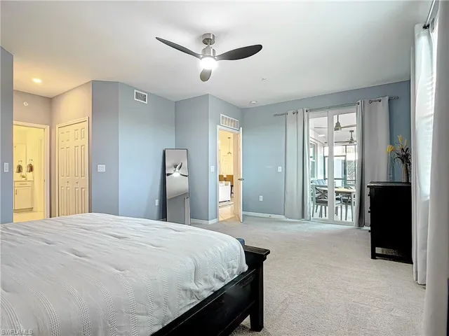 Carpeted bedroom featuring access to exterior, a closet, ensuite bathroom, and ceiling fan