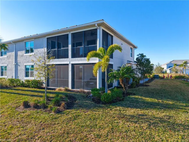 Back of house featuring a sunroom and a yard