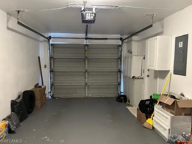 Garage featuring electric panel and a garage door opener