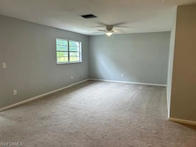 Living room featuring light carpet and ceiling fan