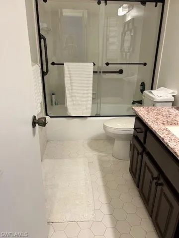 Bathroom with enclosed tub / shower combo and vanity