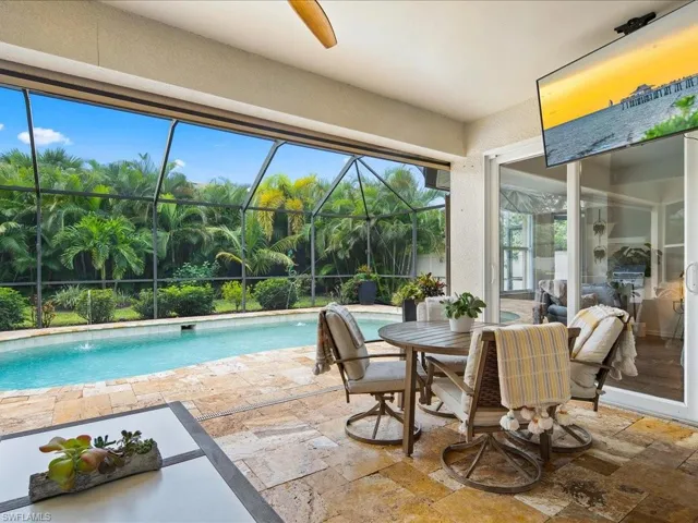 View of pool featuring pool water feature, a patio, and a lanai