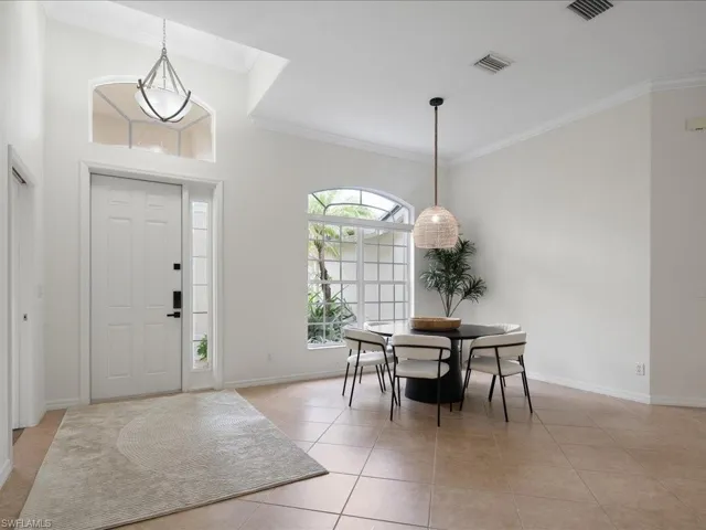 Tiled foyer featuring crown molding
