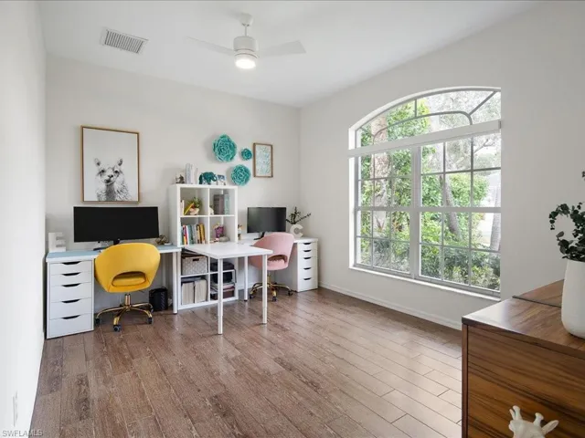 Office area with hardwood / wood-style floors and ceiling fan