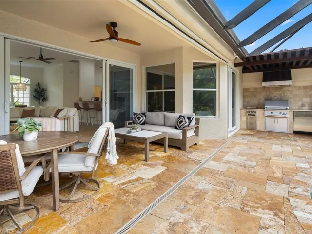 View of patio featuring an outdoor kitchen, ceiling fan, a grill, and an outdoor hangout area