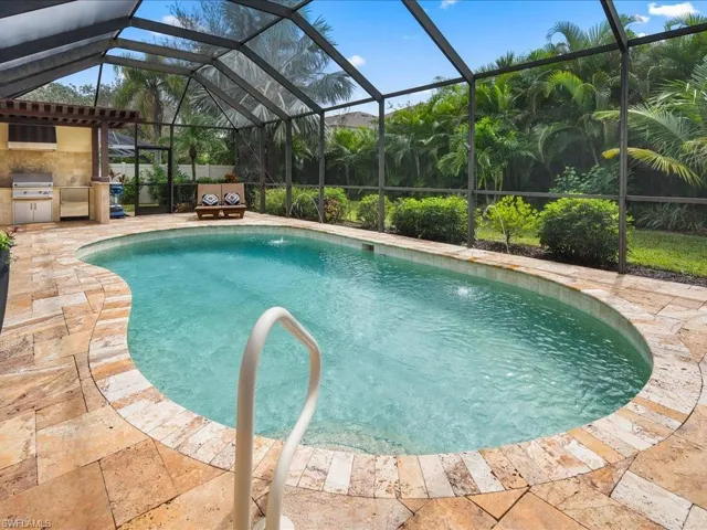 View of pool featuring grilling area, area for grilling, pool water feature, a lanai, and a patio
