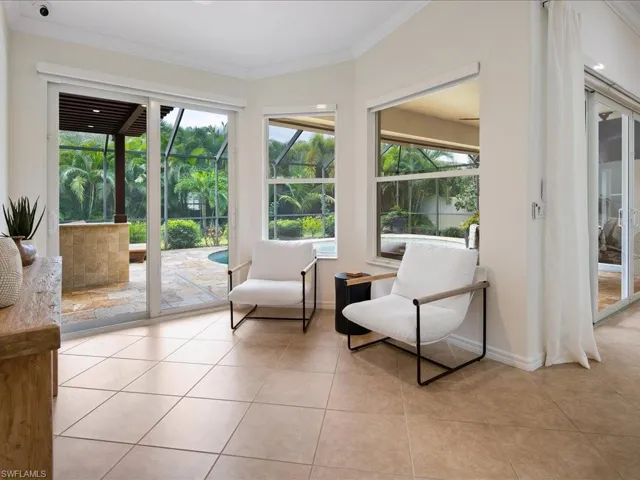 Living area featuring crown molding and light tile patterned floors
