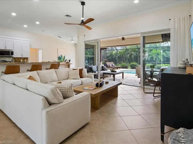 Tiled living room with ceiling fan and ornamental molding