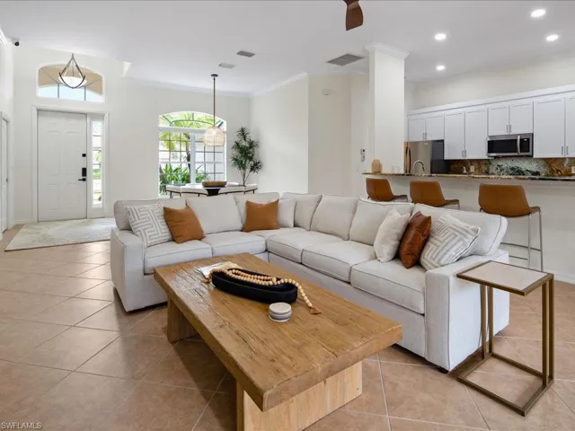 Tiled living room featuring crown molding