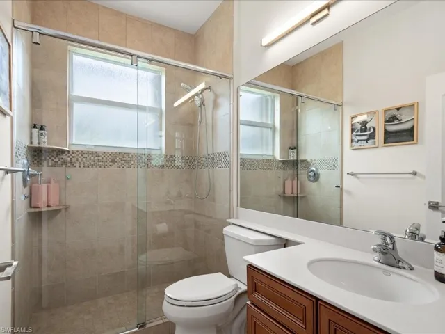 Bathroom featuring vanity, toilet, and walk in shower