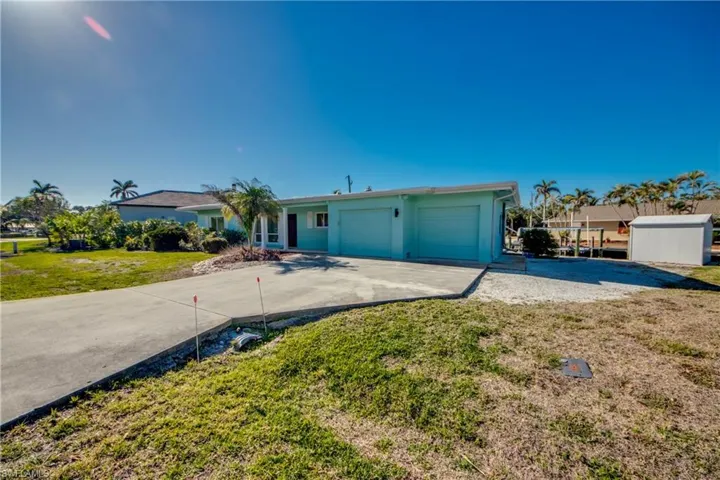 Single story home with a garage and a front lawn