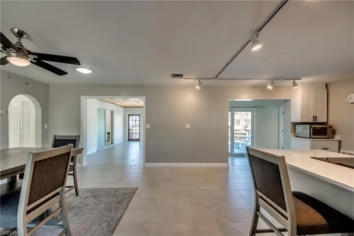 Tiled dining room featuring ceiling fan, a healthy amount of sunlight, and track lighting