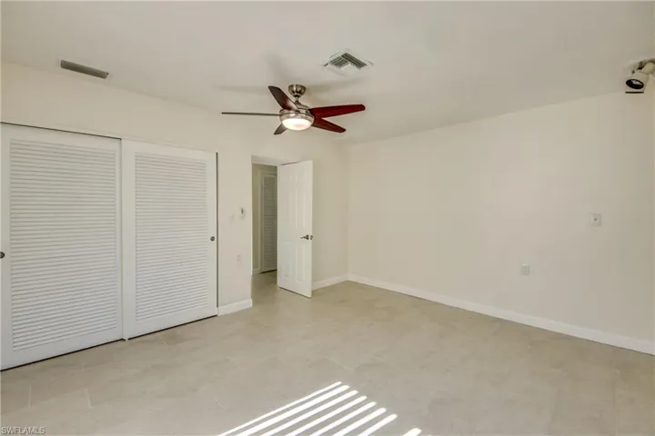 Unfurnished bedroom featuring light tile patterned floors, a closet, and ceiling fan
