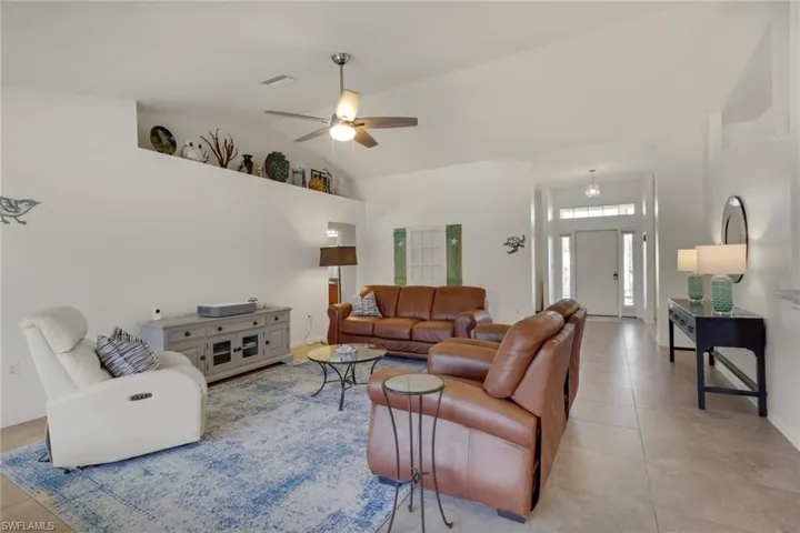 Living area featuring ceiling fan and lofted ceiling