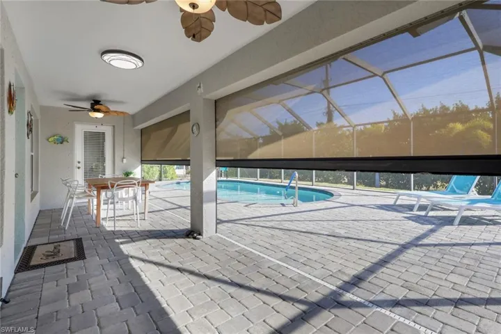 Swimming pool featuring a patio, outdoor dining area, and glass enclosure