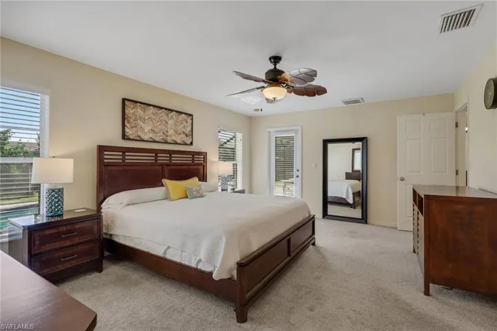 Bedroom with light colored carpet, ceiling fan, and access to outside