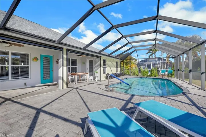 Outdoor pool featuring a sunroom, a patio area, and a lanai