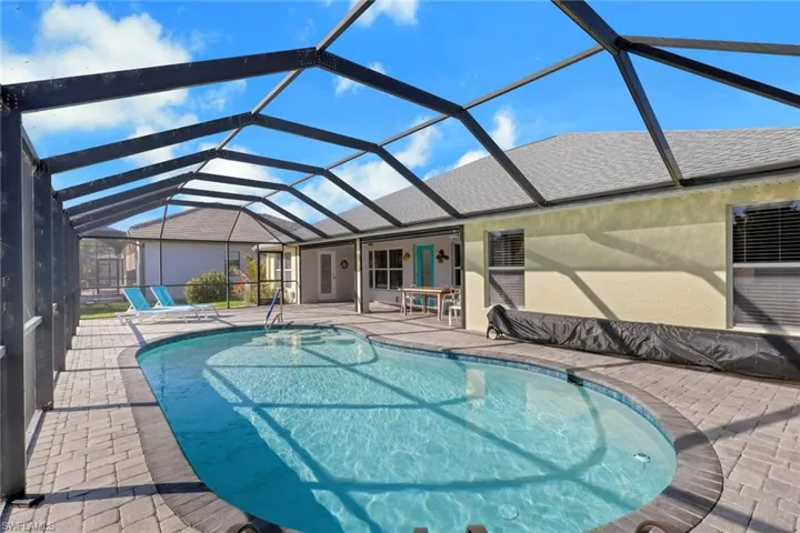 Swimming pool with a sunroom, a patio, and a lanai