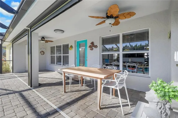 View of patio featuring a ceiling fan, outdoor dining space, and a sunroom