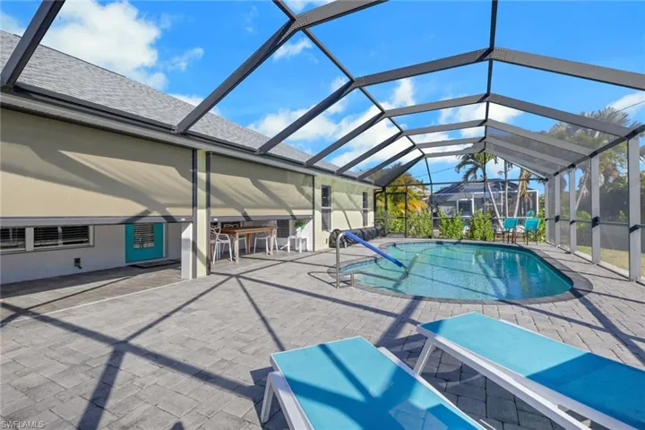 Swimming pool with a patio, glass enclosure, and a sunroom