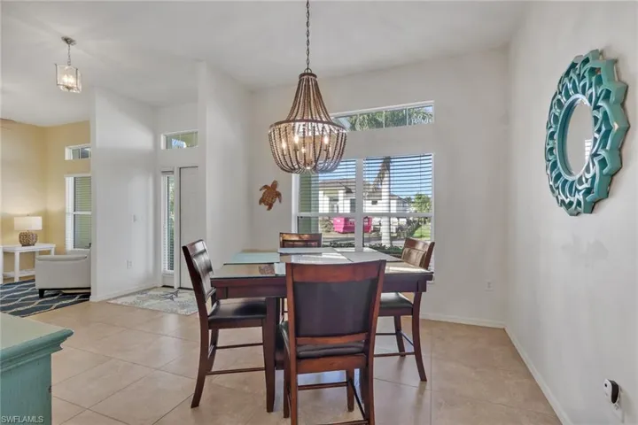 Dining space with plenty of natural light, light tile patterned floors, and suspended lighting