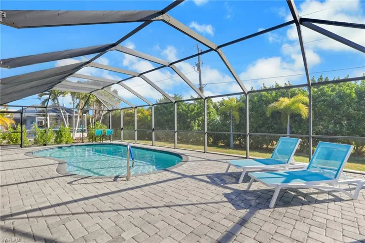 Swimming pool featuring a sunroom, glass enclosure, and a patio