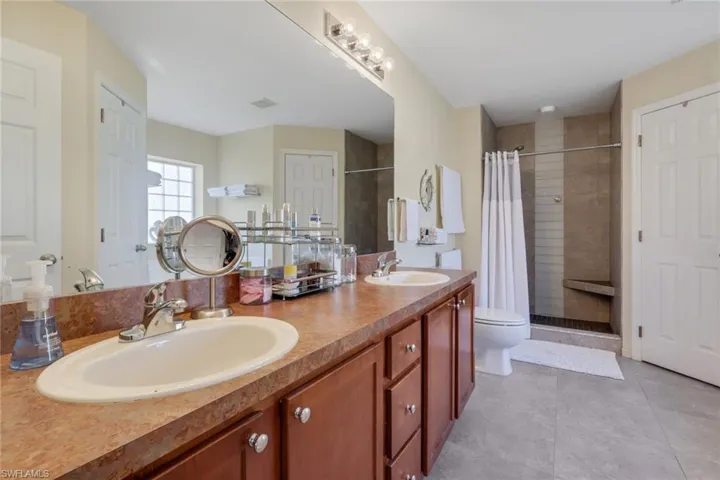 Full bath with double vanity and a stall shower