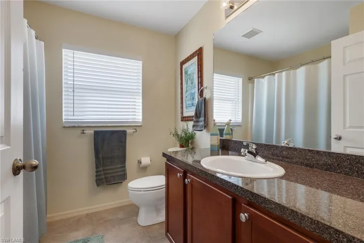 Bathroom with vanity, a shower with shower curtain, and light tile patterned floors