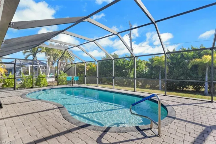Swimming pool featuring a sunroom, glass enclosure, and a patio