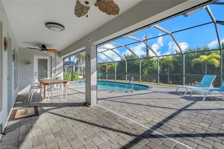 Swimming pool featuring a patio, outdoor dining space, a sunroom, and glass enclosure