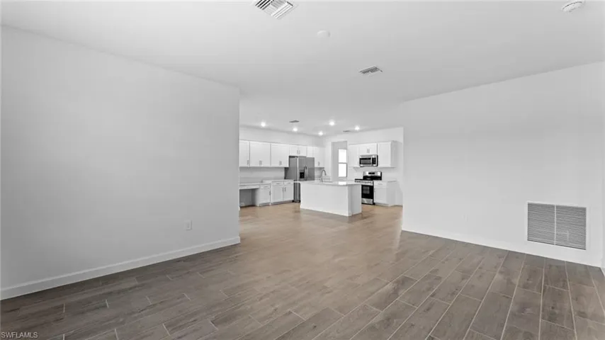 Unfurnished living room featuring hardwood / wood-style flooring and sink