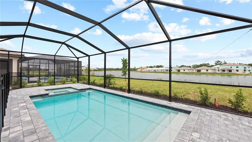 View of pool featuring a patio, an in ground hot tub, a lanai, and a lawn
