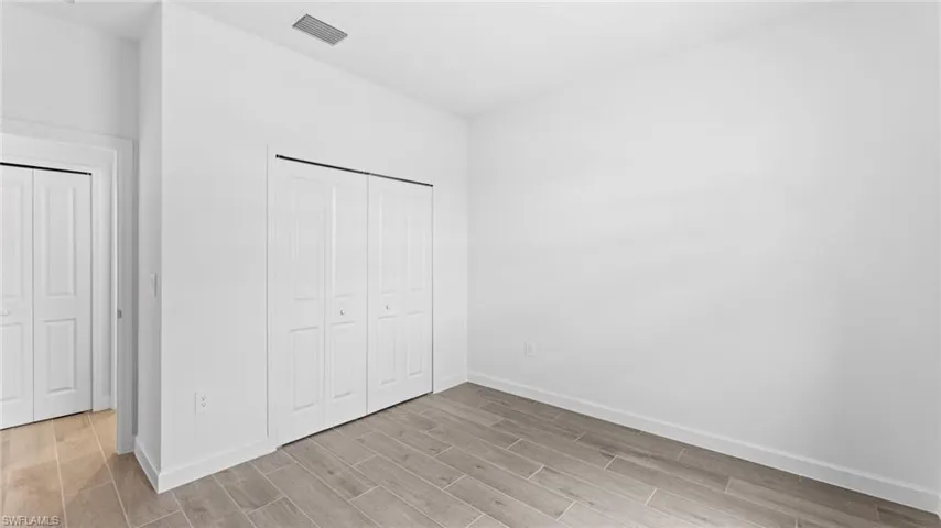 Unfurnished bedroom featuring light hardwood / wood-style flooring and a closet