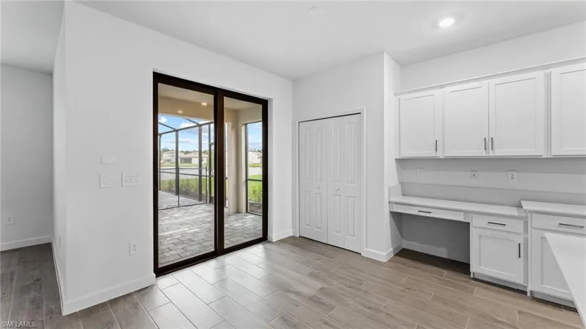 Doorway to outside featuring light wood-type flooring and built in desk