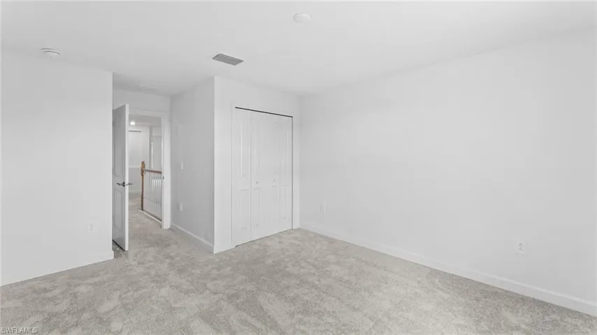 Unfurnished bedroom featuring carpet and a closet